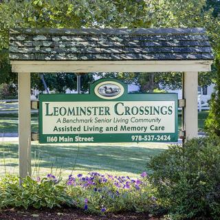 Sign for Leominster Crossings, a residential senior living community offering assisted living and memory care.