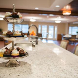 An elegant display of assorted desserts on a tiered stand in a modern kitchen setting.