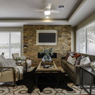 A cozy and modern living room with a stone fireplace and comfortable seating.