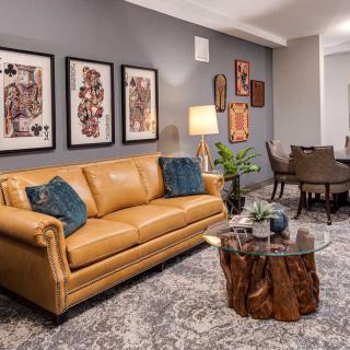 A stylish living room featuring a leather sofa, wooden coffee table, and modern wall art.