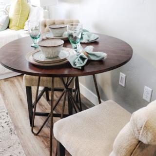 A beautifully set round dining table, perfect for a cozy meal with friends or family.