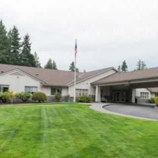A facility with a landscaped lawn and flagpole in front.