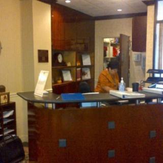 A reception area in an office with a person working at the desk.