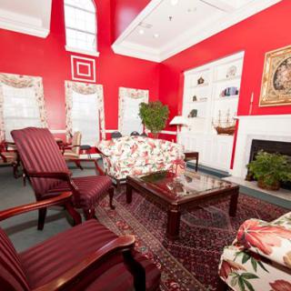 A traditional living room with red walls and classic furniture.