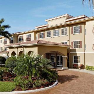 A well-maintained residential building with palm trees and a landscaped entrance.
