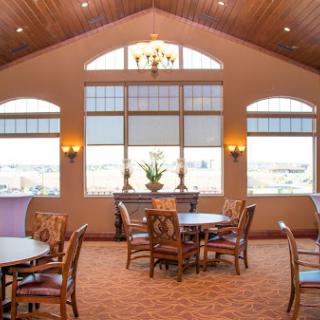 A well-lit dining area featuring elegant furnishings and large windows.