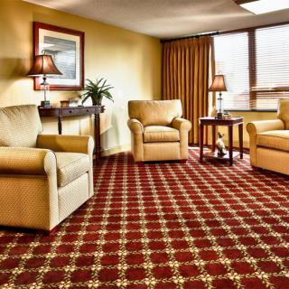 A cozy living room with armchairs and a patterned carpet.