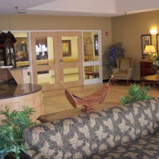 A cozy lobby area featuring comfortable seating, decorative plants, and a reception desk.