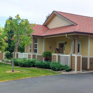 A charming single-story house with a welcoming front porch and well-maintained garden.