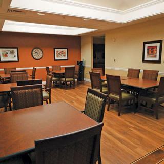 A modern meeting room with tables and chairs arranged neatly.