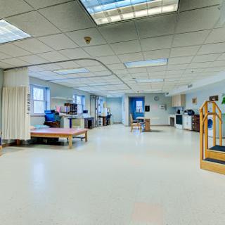 A spacious rehabilitation therapy room equipped for patient care and therapy activities.