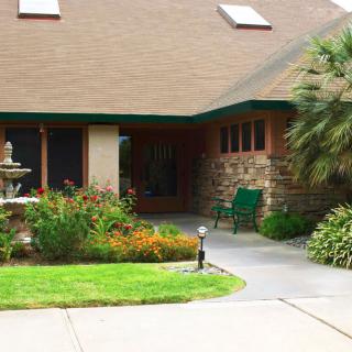 A charming house with a well-maintained garden and fountain in the front yard.