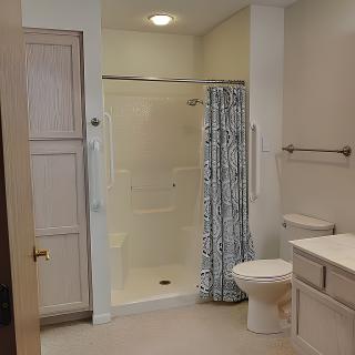 A modern bathroom with a glass shower, toilet, and sink.