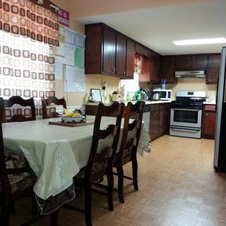 A cozy kitchen with a dining area, featuring wooden cabinets and modern appliances.