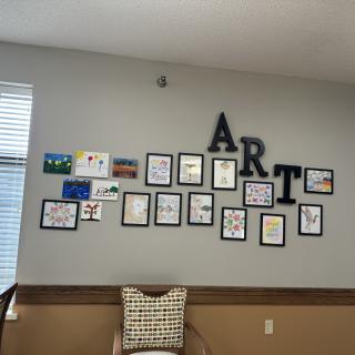 A wall display of various framed artworks arranged under large letters spelling 'ART'.