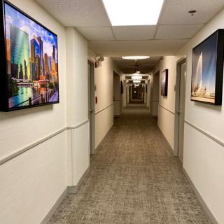 A long, well-lit hallway with artwork on the walls.