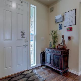 A cozy entryway with a wooden cabinet adorned with decor and artwork on the walls.