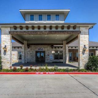 A modern building entrance with a stone facade and canopy.