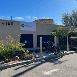 A business building with bicycles parked outside, featuring a prominent sign.