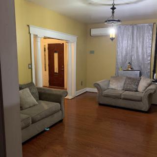 A cozy living room with soft seating and warm yellow walls.