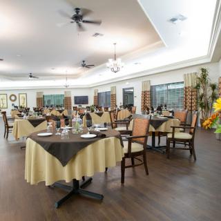 An elegantly set dining area with neatly arranged tables and chairs, featuring tasteful decor and ambient lighting.