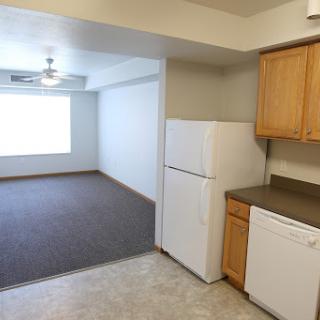 A spacious apartment featuring a kitchen with modern appliances and an open living area.
