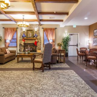 A cozy and elegantly furnished living room with a fireplace, comfortable seating, and warm lighting.