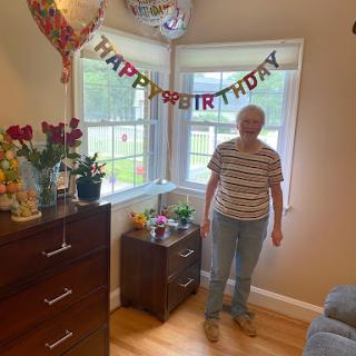A joyful birthday celebration in a cozy room with decorations and flowers.