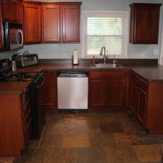 A modern kitchen with wooden cabinets and stainless steel appliances.