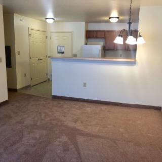 A cozy apartment featuring an open floor plan with a living area and a kitchen separated by a breakfast bar.