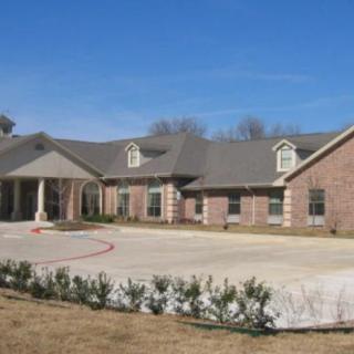 A large residential building with a brick exterior and a driveway.