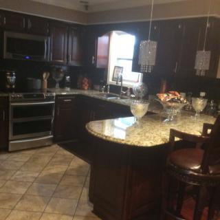 Modern kitchen with dark wood cabinets and granite countertops.