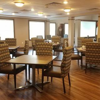 Modern dining area with patterned chairs and wooden tables.