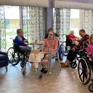 Elderly residents sitting together in a care facility.