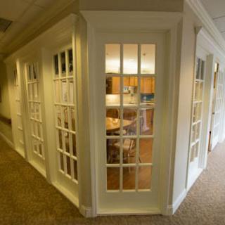 A modern office space with glass-paneled doors and a view of the interior furnishings.
