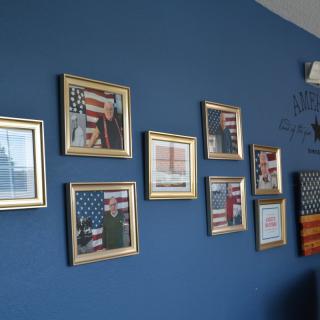 A blue wall decorated with framed patriotic pictures featuring the American flag.