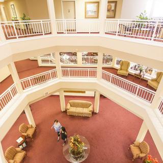 A spacious hotel lobby with multiple levels, featuring comfortable seating areas and elegant decor.
