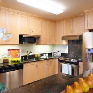 A modern kitchen with wooden cabinets and stainless steel appliances.