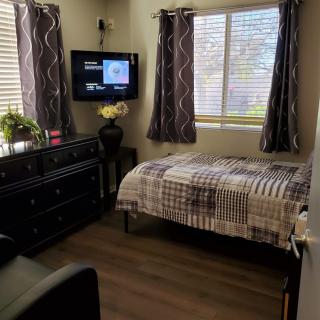 Cozy bedroom with a single bed, TV, and dresser.