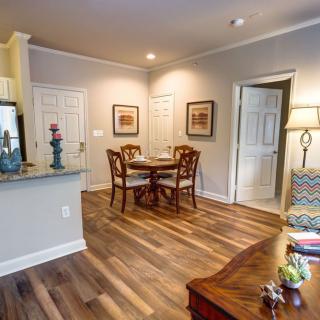 A cozy apartment living space featuring a small dining area with wooden flooring.