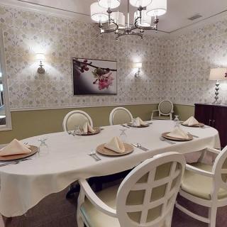 A beautifully decorated dining room featuring a table with place settings, elegant chairs, and ambient lighting.