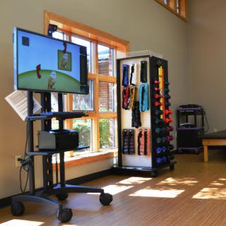 A rehabilitation space featuring interactive therapy equipment and various exercise tools for fitness and wellness.