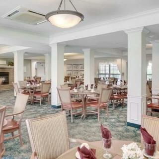 An elegantly designed dining area with neatly arranged tables and chairs, featuring soft lighting and spacious seating.
