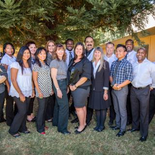 A diverse team gathered outdoors for a group photo, showcasing unity and professionalism.