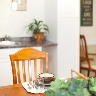 A cozy dining area featuring a simple table setting and a touch of greenery.