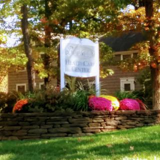 A beautifully landscaped area featuring a sign surrounded by vibrant flowers in autumn.