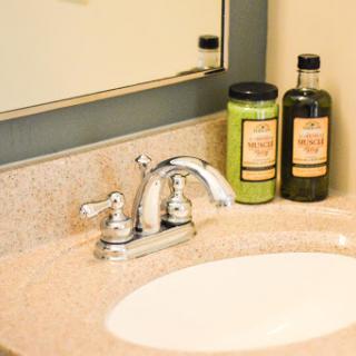 A stylish bathroom sink with a chrome faucet and neatly arranged personal care bottles.
