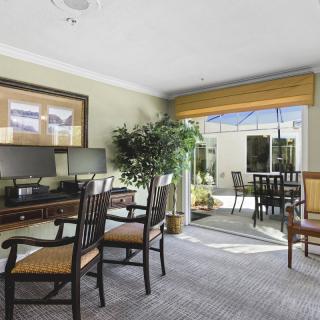 A well-lit office interior with desks, chairs, and a view of the outside patio.