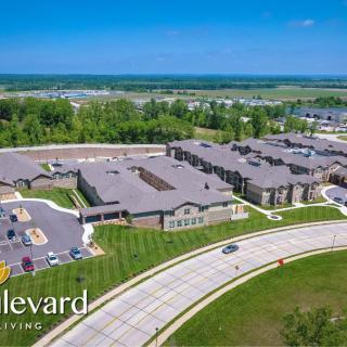 Aerial view of a residential complex with surrounding greenery and roads.