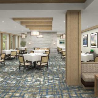 A modern restaurant interior with neatly arranged tables and chairs, featuring elegant lighting and stylish decor.
